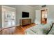 Bedroom with hardwood flooring, television, and access to the hallway and bathroom at 102 W Almeria Rd, Phoenix, AZ 85003