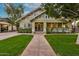 Charming home featuring a well-manicured lawn, lush landscaping, and a welcoming walkway to the front door at 102 W Almeria Rd, Phoenix, AZ 85003