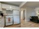 Bright kitchen featuring white appliances and cabinetry and opening to living area with wood-look floors at 102 W Almeria Rd, Phoenix, AZ 85003