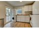 Well-lit kitchen equipped with washer and dryer, all-white cabinetry and appliances, and wood-look floors at 102 W Almeria Rd, Phoenix, AZ 85003