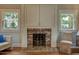 Living room showcasing a brick fireplace, built-in cabinets, and natural light from two windows at 102 W Almeria Rd, Phoenix, AZ 85003