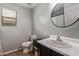 Bright bathroom featuring a modern vanity and a round mirror at 1059 S Cheshire Ln, Gilbert, AZ 85296