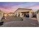 Well-kept backyard featuring desert landscaping, string lights, and covered patio at 10772 W Woodland Ave, Avondale, AZ 85323