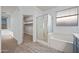 Well-lit bathroom, with glass-enclosed shower and tub, leading to a carpeted walk-in closet at 10772 W Woodland Ave, Avondale, AZ 85323