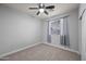Bedroom with a ceiling fan and window allowing natural light and plush carpet at 10772 W Woodland Ave, Avondale, AZ 85323