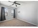 Clean bedroom featuring neutral carpet, ceiling fan, and curtains at 10772 W Woodland Ave, Avondale, AZ 85323