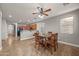 Dining room with wood table, chairs and a ceiling fan with open view into the kitchen at 10772 W Woodland Ave, Avondale, AZ 85323