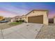 Charming home featuring a manicured lawn, desert landscaping, and a two-car garage at 10772 W Woodland Ave, Avondale, AZ 85323