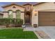 Inviting entryway featuring a dark wooden door, arched entrance, and manicured landscaping at 10772 W Woodland Ave, Avondale, AZ 85323