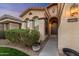 The front of this home shows a front door with an arched entryway and well-kept landscaping at 10772 W Woodland Ave, Avondale, AZ 85323