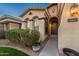 The front of this home shows a front door with an arched entryway and well-kept landscaping at 10772 W Woodland Ave, Avondale, AZ 85323