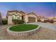 Charming home featuring desert landscaping, and a two-car garage, complemented by a manicured lawn at 10772 W Woodland Ave, Avondale, AZ 85323