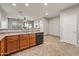 Kitchen with stainless steel sink, wooden cabinets, and tile flooring leading to dining area at 10772 W Woodland Ave, Avondale, AZ 85323