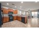 Open kitchen with wood cabinets, tile flooring, recessed lighting, and a view into the dining area at 10772 W Woodland Ave, Avondale, AZ 85323