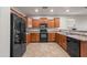 Kitchen featuring a black refrigerator, oven, microwave and wood cabinets at 10772 W Woodland Ave, Avondale, AZ 85323
