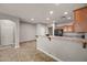 Open-concept kitchen with a breakfast bar, wood cabinets, and black appliances at 10772 W Woodland Ave, Avondale, AZ 85323