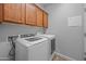 Laundry room with washer and dryer and cabinets at 10772 W Woodland Ave, Avondale, AZ 85323