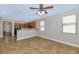 Open-concept living room with lots of natural light, tile floors, and access to the kitchen at 10772 W Woodland Ave, Avondale, AZ 85323