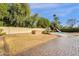 Backyard with grass, mature trees, a slide and a swimming pool with a beige concrete surround at 12125 N 91St Way, Scottsdale, AZ 85260