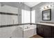 Modern bathroom equipped with a glass-enclosed shower, soaking tub, and dual-sink vanity at 12125 N 91St Way, Scottsdale, AZ 85260