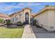 Beige single-Gathering home featuring a front entrance with an arched alcove and beautiful desert landscaping at 12125 N 91St Way, Scottsdale, AZ 85260