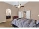 Bright main bedroom featuring a ceiling fan and access to a full bathroom and closet at 12125 N 91St Way, Scottsdale, AZ 85260