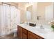 Bathroom features double sinks, decorative mirrors, and a shower with a floral curtain at 12508 W Highland Ave, Litchfield Park, AZ 85340