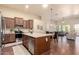 Bright kitchen with an island, stainless steel appliances, and a view into the living room at 12508 W Highland Ave, Litchfield Park, AZ 85340