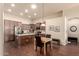 This open kitchen features stainless steel appliances, an island with seating, and a dining area at 12508 W Highland Ave, Litchfield Park, AZ 85340