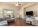Bright living room with a ceiling fan, wood flooring, and backyard views at 12508 W Highland Ave, Litchfield Park, AZ 85340