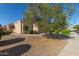 Desert home with xeriscaping, sidewalk, and a flowering tree in the front yard at 12720 W Mandalay Ln, El Mirage, AZ 85335