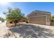 Home with a two-car garage, xeriscaped yard, and flowering tree at 12720 W Mandalay Ln, El Mirage, AZ 85335