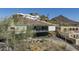 Modern home with expansive glass windows and desert landscaping, nestled hillside among natural terrain at 1340 E Las Palmaritas Dr, Phoenix, AZ 85020