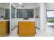 Bright walk-in closet featuring a central island with a marble countertop and a view to the exterior at 1340 E Las Palmaritas Dr, Phoenix, AZ 85020