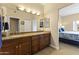 Bathroom featuring double sinks, granite counters, and wood cabinetry next to a bedroom at 13700 N Fountain Hills Blvd # 365, Fountain Hills, AZ 85268