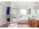 Well-lit bathroom with tub, shower, and vanity at 14363 W Acapulco Ln, Surprise, AZ 85379