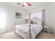 Bedroom with a vintage bed frame, soft natural light, carpet, and a pink ceiling fan at 14363 W Acapulco Ln, Surprise, AZ 85379