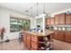 Charming kitchen island with bar stool seating, cabinets and display shelves at 14363 W Acapulco Ln, Surprise, AZ 85379