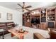 Comfortable living room boasts custom built-ins and a stylish ceiling fan at 14363 W Acapulco Ln, Surprise, AZ 85379