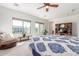 Bright and airy main bedroom featuring an inviting seating area, large windows and comfortable bed at 14363 W Acapulco Ln, Surprise, AZ 85379