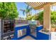 Outdoor kitchen featuring a grill, smoker, sink, and counter space for cooking and entertaining at 14363 W Acapulco Ln, Surprise, AZ 85379