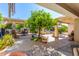 Expansive covered patio with an outdoor kitchen, mature landscaping, and comfortable seating, perfect for entertaining guests at 14363 W Acapulco Ln, Surprise, AZ 85379