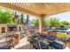 Covered patio with a fireplace, a dining table, and a view of the pool and backyard at 14363 W Acapulco Ln, Surprise, AZ 85379