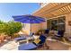 Inviting patio featuring lounge chairs, a sun umbrella, and serene backyard views at 14363 W Acapulco Ln, Surprise, AZ 85379