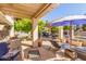 Beautiful outdoor patio with an umbrella, lounge furniture, and lush landscaping at 14363 W Acapulco Ln, Surprise, AZ 85379