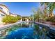 Backyard pool reflects the blue sky with patio space for entertaining, mature fruit trees, and lush landscaping at 14363 W Acapulco Ln, Surprise, AZ 85379