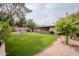 Spacious backyard featuring artificial grass and mature landscaping with a brick home exterior at 14625 N 25Th Pl, Phoenix, AZ 85032