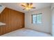 Bright bedroom featuring wood-paneled accent wall and a ceiling fan, bathed in natural light from the window at 14625 N 25Th Pl, Phoenix, AZ 85032