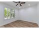 Bright bedroom with a ceiling fan, hardwood floors, and plantation shutters on the window at 15046 W Cooperstown Way, Surprise, AZ 85374