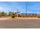 Community baseball park behind a landscaped entrance, featuring flags, and street side parking spots at 15046 W Cooperstown Way, Surprise, AZ 85374